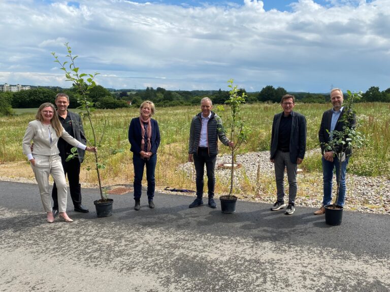 Geschäftsführer Lydia Bahn und Thomas Bahn gemeinsam mit der leitenden Verwaltungsbeamtin Martina Hansen, Jürgen Ubben von Vineta, Bürgermeister Thomas Haß und Sebastian Kloth von L&S Digital (v. links) vor dem neuen Gewerbegebiet Dreikronen in Schwentinental. (Foto: Stadt Schwentinental)